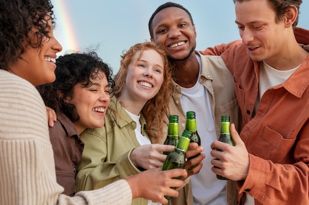 Friends smiling and drinking beer during outdoor party