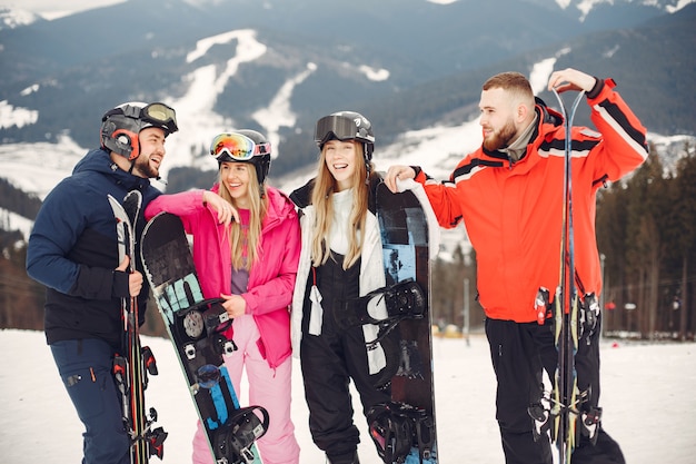 Friends in snowboard suits. Sports people on a mountain with a snowboard. People with skis in the hands on the horizon. Concept on Sports