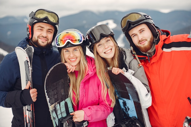 Friends in snowboard suits. Sports people on a mountain with a snowboard. People with skis in the hands on the horizon. Concept on Sports