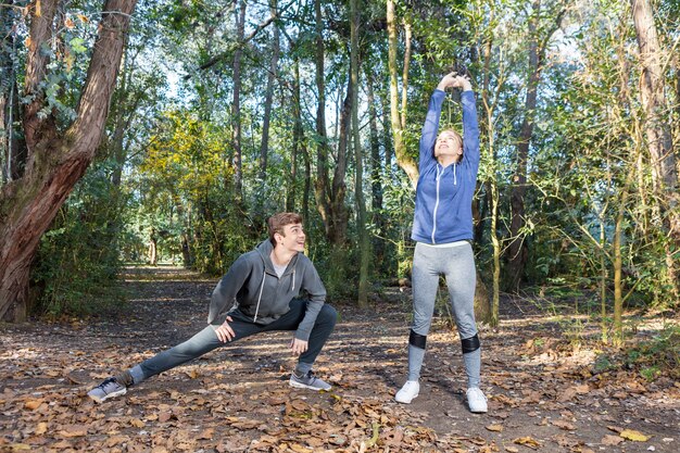 Friends in sportswear doing stretches on a sunny day