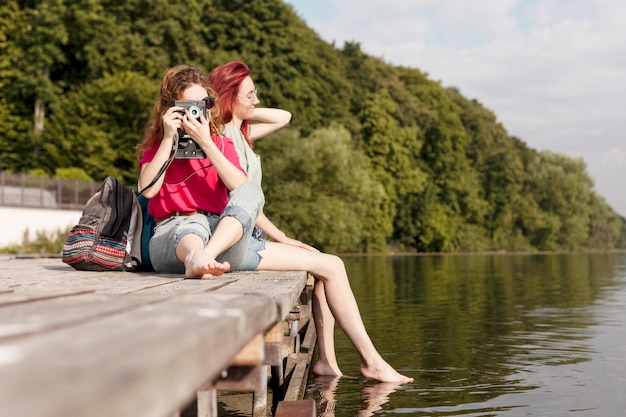 Free Photo friends staying on dock and taking photos