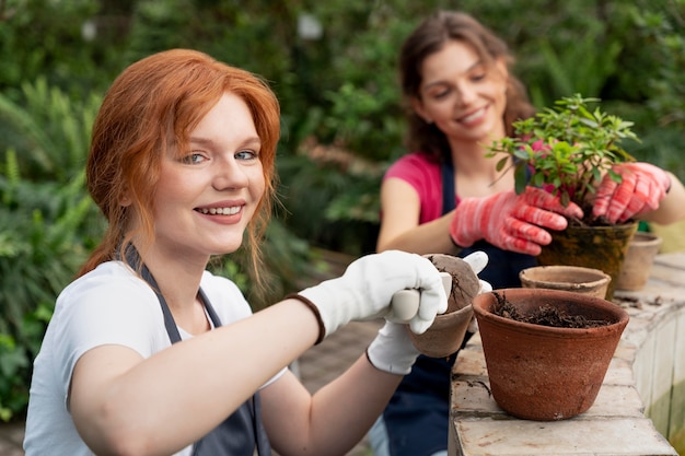 Free photo friends taking care of their plants in a greenhouse