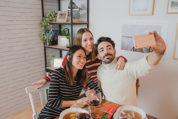 Friends taking selfie at christmas dinner