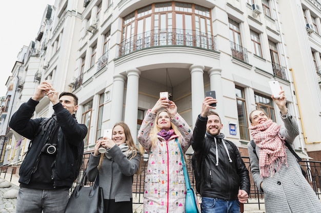 Free Photo friends taking shots with gadgets on street