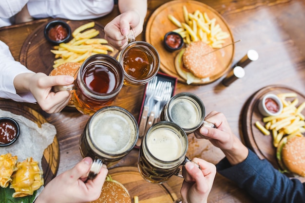 Friends toasting with beer in restaurant