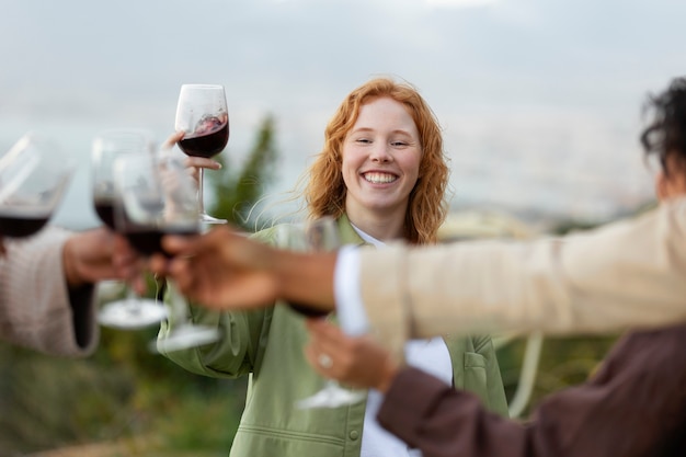 Free photo friends toasting with glasses of wine during outdoor party