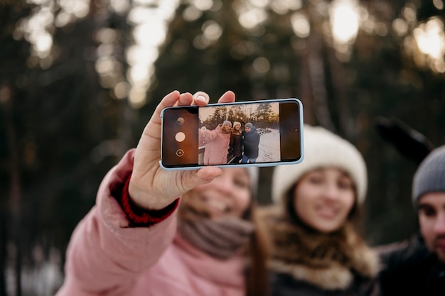 Friends together taking selfie outdoors in winter