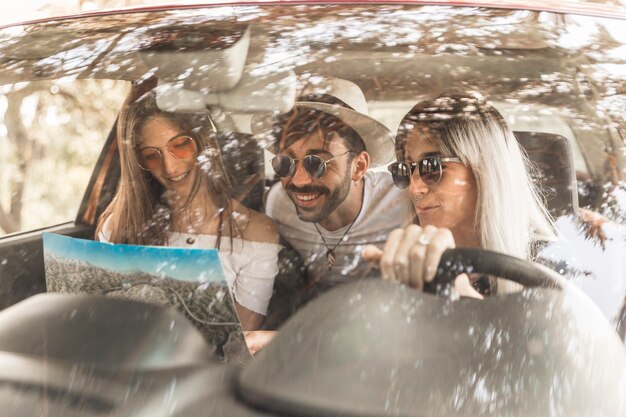 Friends travelling in car looking at map