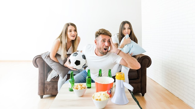 Friends watching football at home