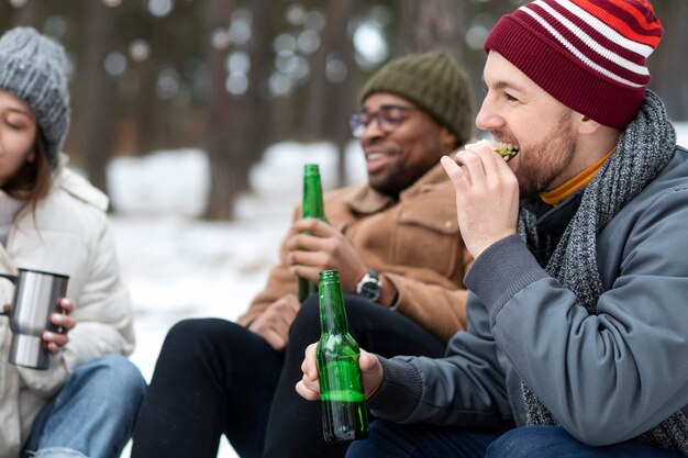 Friends with bottles and food in nature