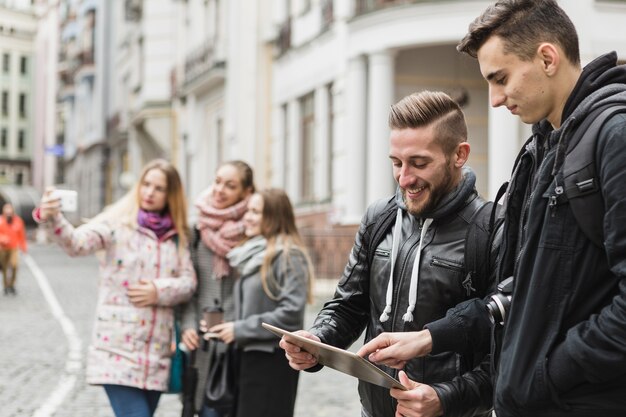 Friends with gadgets on street