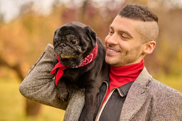 Friendship. A happy smiling man with his dog in the park