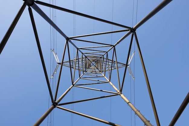 Free photo frog's eye view of an electrical pole against a clear blue sky