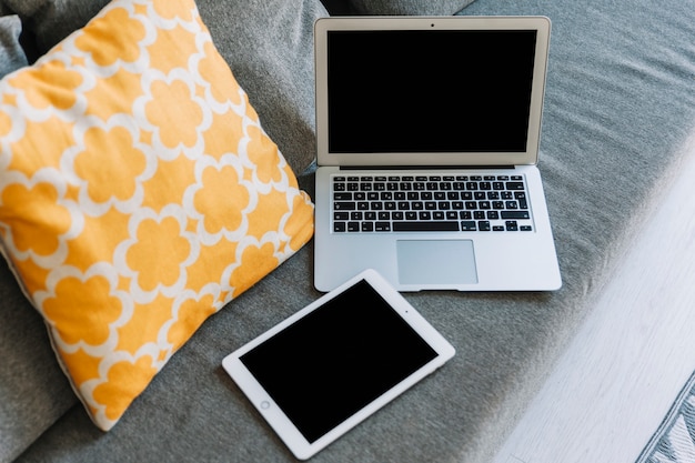 From above tablet and laptop on sofa