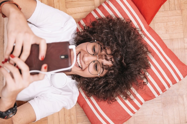 Free Photo from above teenager smiling and using smartphone