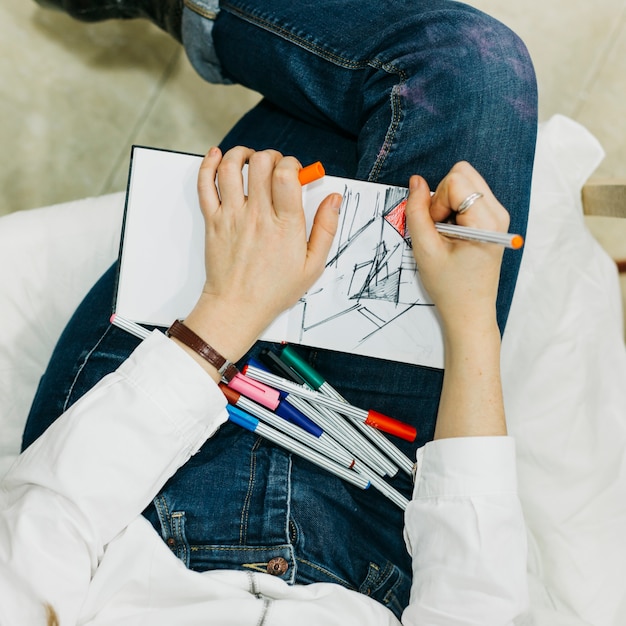 Free photo from above woman drawing with fine liners