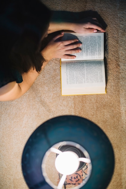 Free Photo from above woman reading near lamp