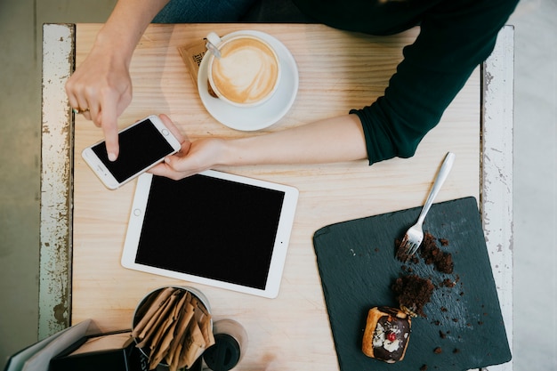 Free Photo from above woman using smartphone in cafe