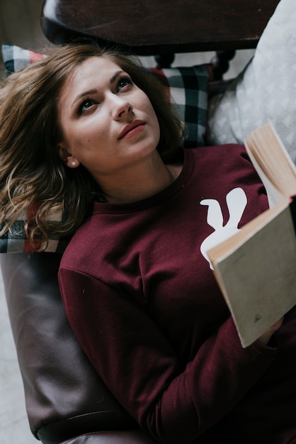 From above woman with book on couch