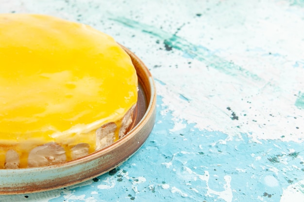 Free photo front close view delicious cake with yellow syrup on light blue surface