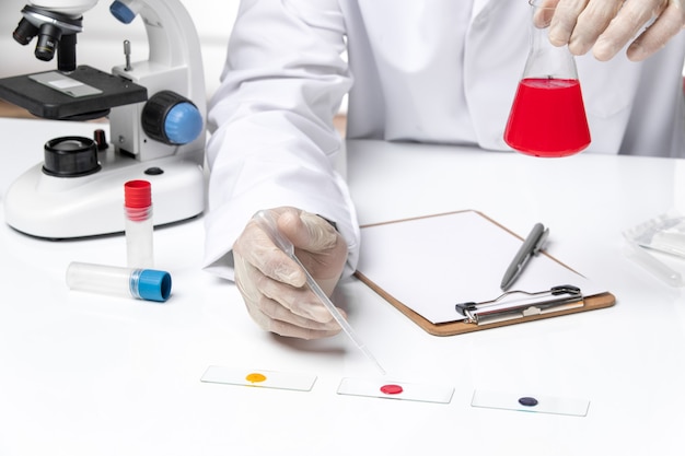 Front close view male doctor in white medical suit on a white space