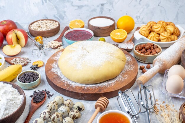 Front close view of raw pastry and set of various foods grater on ice background