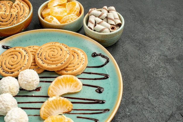 Front close view sweet biscuits with coconut candies on grey desk biscuit cookies sweet