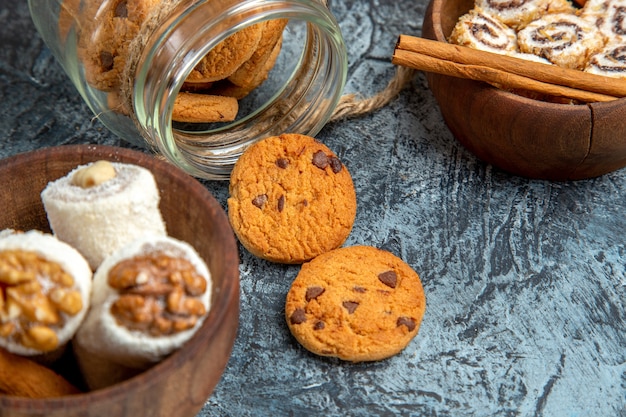 Front close view of sweet cookies with confitures on dark surface