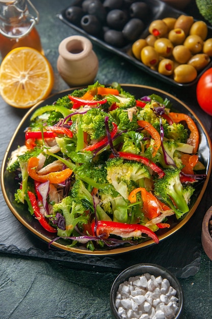 Free photo front close view of vegan salad with fresh ingredients in a plate on black board