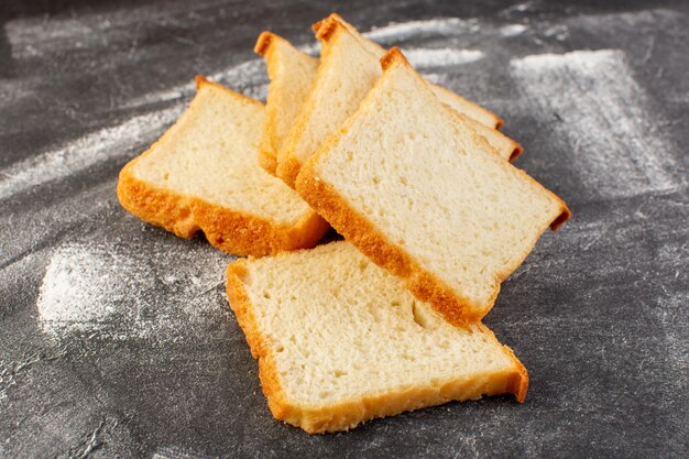 Front close view white bread loafs sliced and tasty isolated on the grey surface