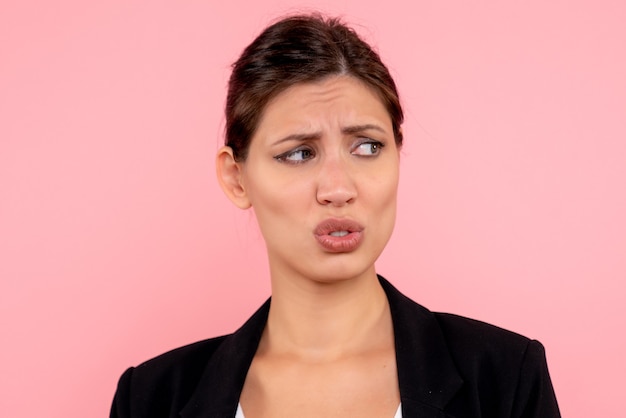 Front close view young female in dark jacket on pink background