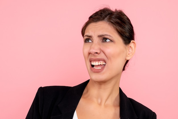 Front close view young female in dark jacket on pink background