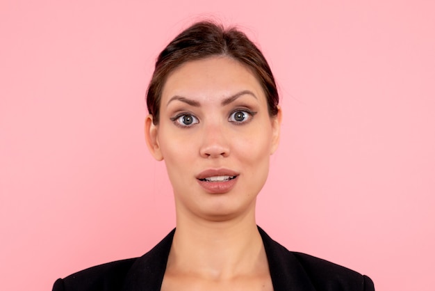 Front close view young female in dark jacket on pink background