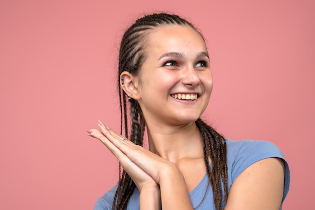 Front close view of young girl happily smiling on pink