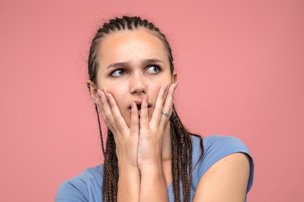 Front close view of young girl nervous and confused on pink