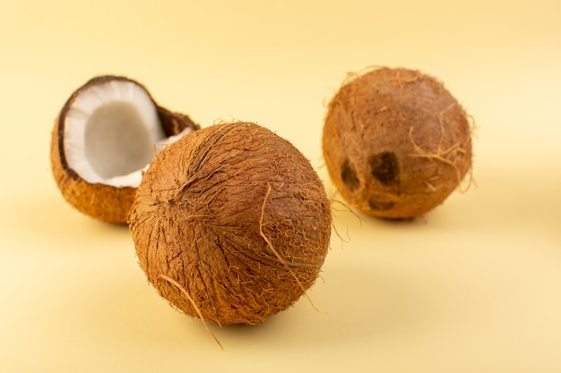 Free photo a front closed up view coconuts whole milky fresh mellow isolated on the cream colored background tropical exotic fruit nut