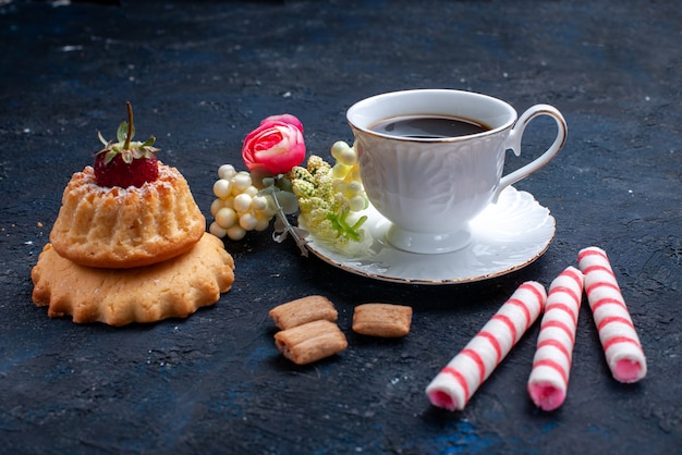 Front closer view cup of coffee with pink stick candies and delicious cake on blue