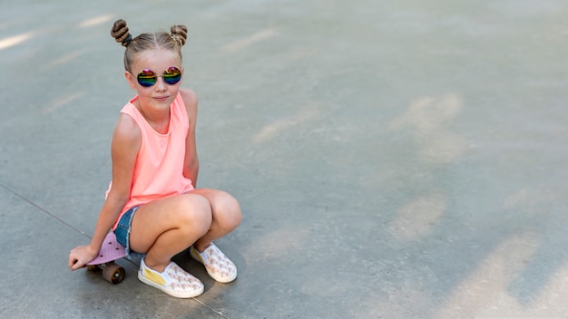 Free Photo front vie of girl sitting on skateboard