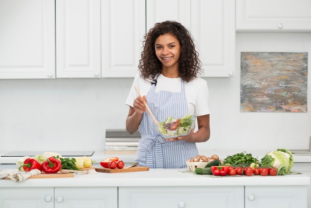 Front view afro american woman preparing salad