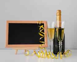 Free photo front view arrangement with chalkboard mock-up and champagne