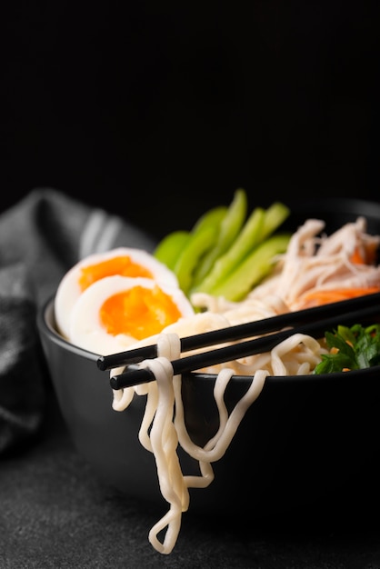 Free photo front view of asian noodles with eggs and vegetables