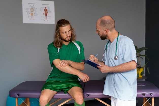 Front view athlete talking to physiotherapist