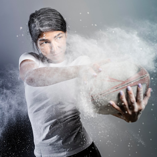 Free photo front view of athletic female rugby player holding ball with powder