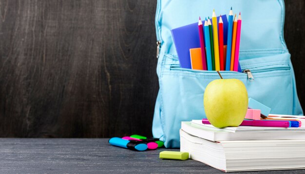 Front view of back to school stationery with colorful pencils and apple