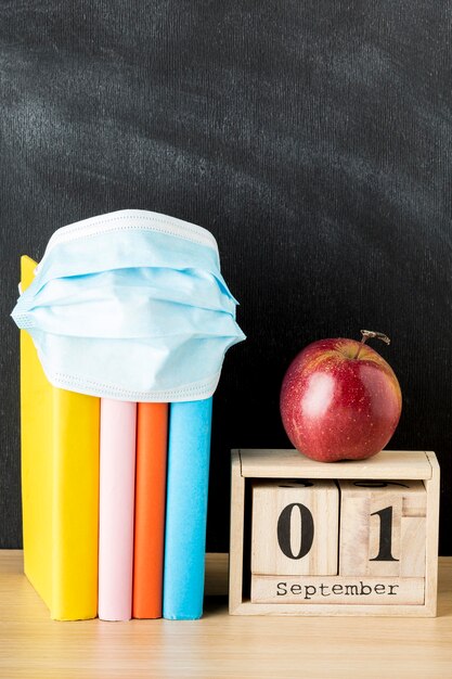 Front view of back to school supplies with medical mask and books