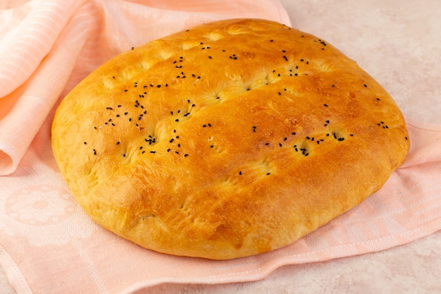 Free photo a front view baked bread hot tasty wrapped in pink towel on pink background bakery dough breakfast