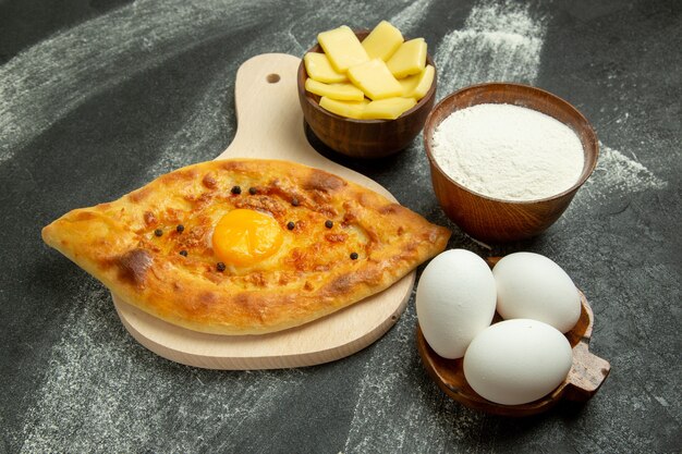 Front view baked egg bread delicious dough bun on the dark desk