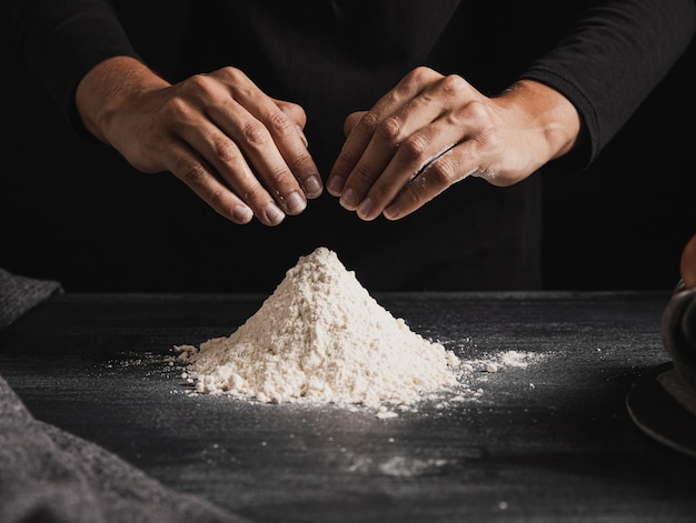 Free photo front view baker hands mixing flour