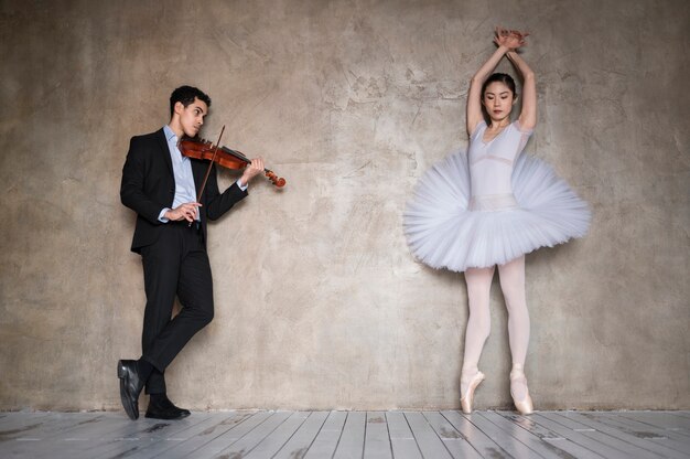 Front view of ballerina dancing to music played by male musician