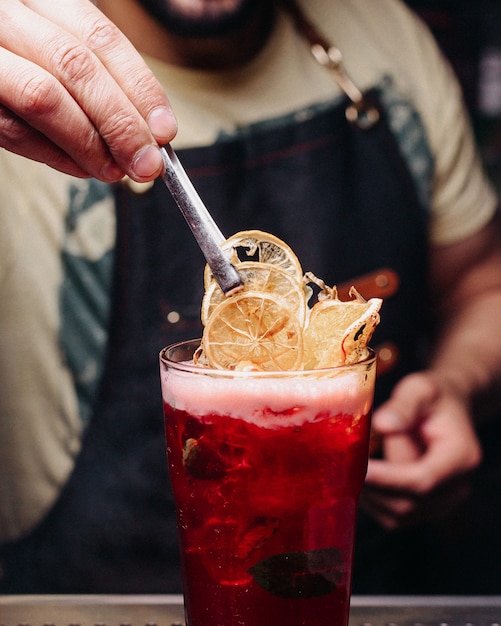 Free photo front view bartender preparing a red drink